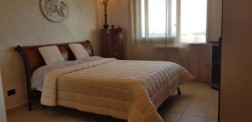 una camera da letto con un letto con una coperta e una finestra di J M VILLA AL MARE CON VEDUTA SPETTACOLARE a Sciacca