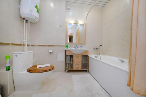 a bathroom with a toilet and a sink and a tub at Apartments on M.Chuikova in Volgograd