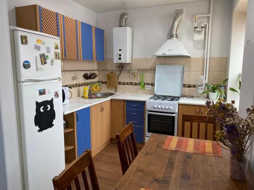 eine Küche mit einem Tisch und einem weißen Kühlschrank in der Unterkunft ART apartment in Schytomyr