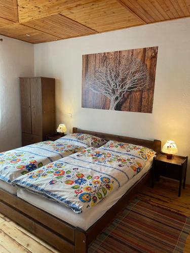 a bed in a bedroom with a painting on the wall at Chata Studnička Šumiac in Šumiac