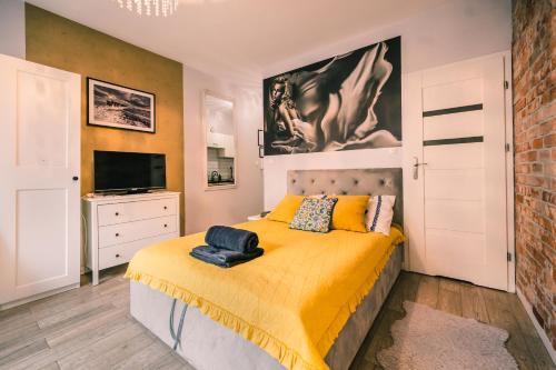 a bedroom with a bed with a yellow blanket at Silver box in Gdańsk
