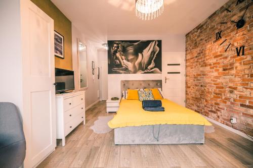 a bedroom with a bed and a brick wall at Silver box in Gdańsk