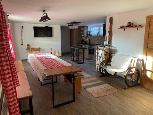 a living room with a bed and a kitchen at Chata Studnička Šumiac in Šumiac