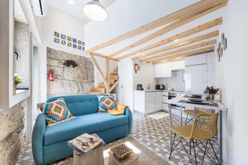 a living room with a blue couch and a kitchen at GuestReady - The New Pateo da Lapa - Casa 3 in Porto