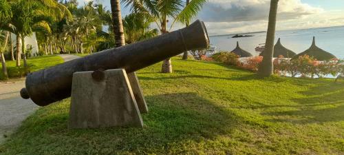 a cannon on the grass next to the ocean at Luxury Villa L'ile Maurice in Pointe aux Cannoniers