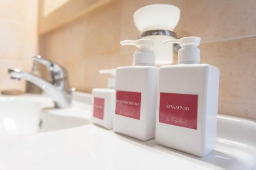 - une salle de bains avec 2 distributeurs de savon sur un lavabo dans l'établissement La Tagliolina, à Monteveglio