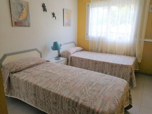 2 camas en una habitación con ventana en Arcos LEK, en Peñíscola