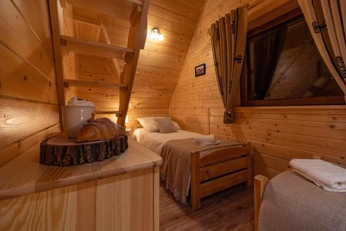 a bedroom with two beds in a log cabin at Kozie Ranczo Domek Bacy in Bańska Niżna