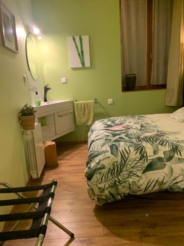 a bedroom with a bed and a bathroom with a sink at Lyon City Home's Bed & Breakfast in Villeurbanne