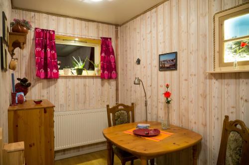 een eetkamer met een houten tafel en een raam bij AmHavern B&B in Haukland