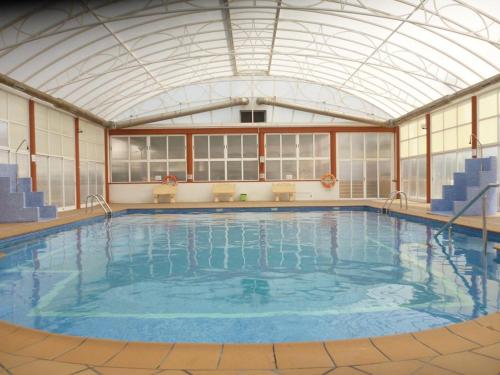 a large indoor swimming pool with a glass ceiling at Bahia de Vera Apartamento Jazmin in Playas de Vera