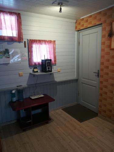 a room with a door and a table with a microwave at Oāze Smiltenē in Smiltene