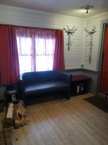 a living room with a blue couch in front of a window at Oāze Smiltenē in Smiltene