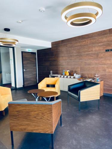 a room with chairs and a table and a kitchen at Intergroup Business & Design Hotel Ingolstadt in Kösching