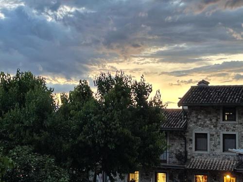 a building with trees in front of a sunset at Agriturismo Clochiatti in Povoletto