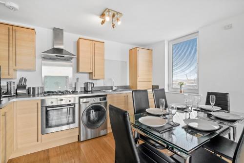 a kitchen with a dining table and a kitchen with a dishwasher at Queens Apartments - Grampian Lettings Ltd in Aberdeen