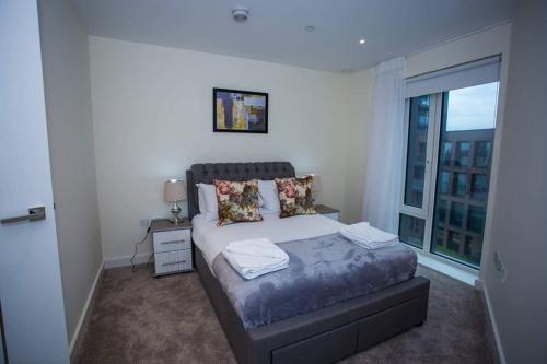 1 dormitorio con cama y ventana grande en UNIQUE 2 BED APARTMENT en Londres
