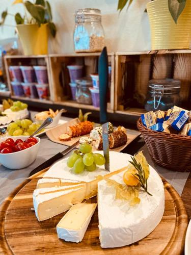 a table with cheese and grapes on a cutting board at Intergroup Business & Design Hotel Ingolstadt in Kösching
