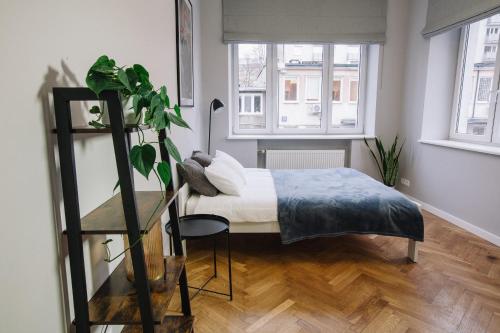 małą sypialnię z łóżkiem i rośliną w obiekcie Warsaw Concierge Flat6 Hoza w Warszawie