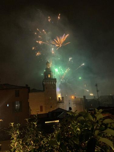 a building with a tower with fireworks in the sky at Hotel Roma in Bologna
