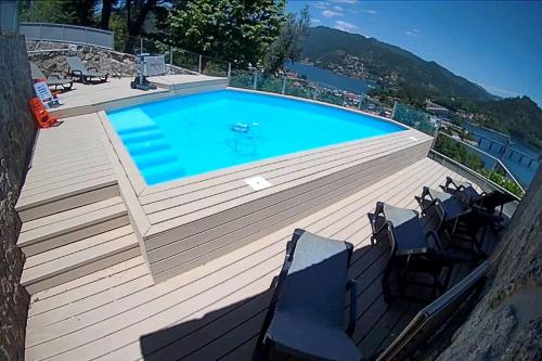 a large swimming pool on a wooden deck with chairs around it at CASA CAPUCINE in Rio Caldo