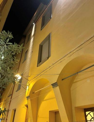 a yellow building with arches on the side of it at Hotel Roma in Bologna
