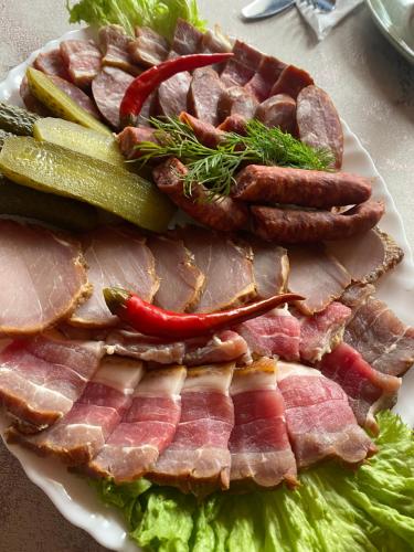 a plate of meat and vegetables on a table at Verkhovinsky Dvor in Kostryna