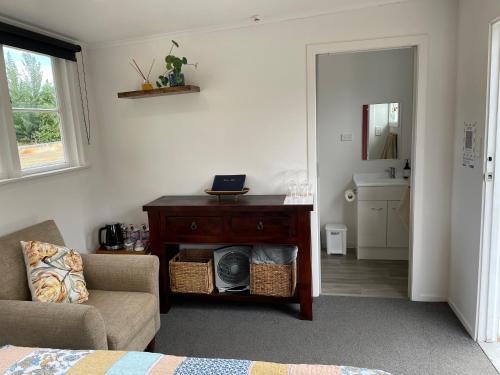 a bedroom with a table and a chair and a mirror at 'The Crib' on Legacy Vineyard in Alexandra