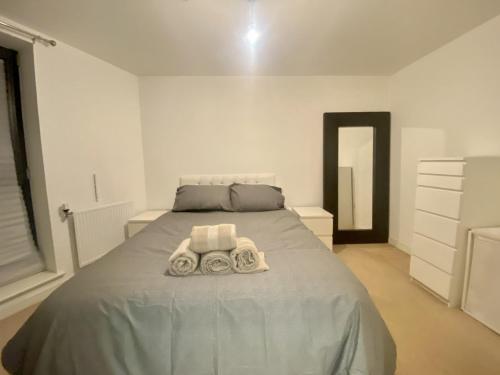 a bedroom with a bed with two towels on it at London Dockside Apartment in London