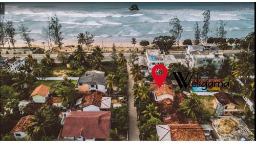 un mapa rojo de una casa frente a la playa en location weligama, en Weligama