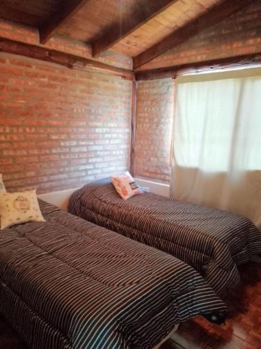 two beds in a room with a window at Don Edmundo Trevelin in Trevelín