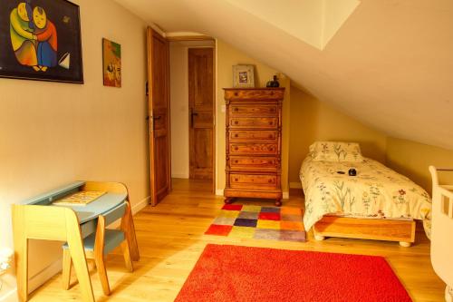 a bedroom with a bed and a dresser and a table at KERBELEG, ferme-manoir du XVè siècle, chambres grand confort in Riec-sur-Bélon