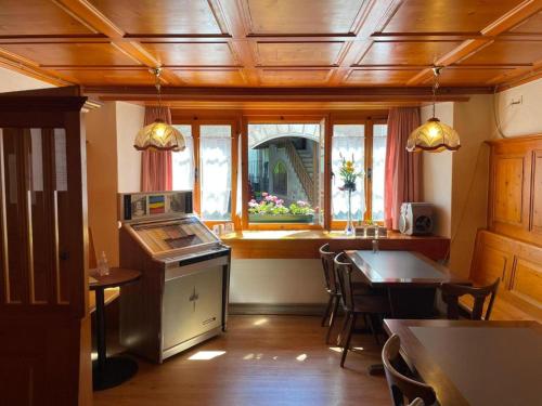 a kitchen with a table and chairs and a window at Casa Job - Gasthaus - Sauna, Whirlpool - Trun in Trun