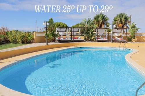 a large swimming pool with chairs around it at Quinta Nova Relax & Spa - Vale del Rey in Carvoeiro