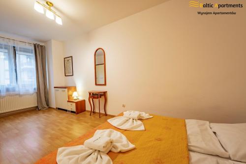 Un dormitorio con dos toallas en una cama. en Baltic Apartments - Zdrojowa, en Świnoujście