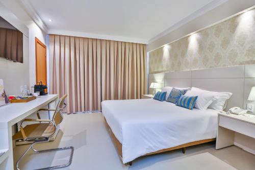 a hotel room with a bed and a desk at Golden Lis Hotel Boutique in Goiânia