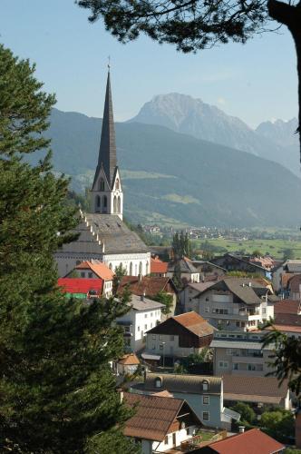 a church with a steeple on top of a city at Hotel-Garni Stern - bed & breakfast & more in Imst