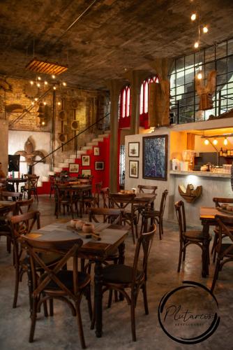 a restaurant with wooden tables and chairs in a room at Posada El Castillo xilitla in Xilitla