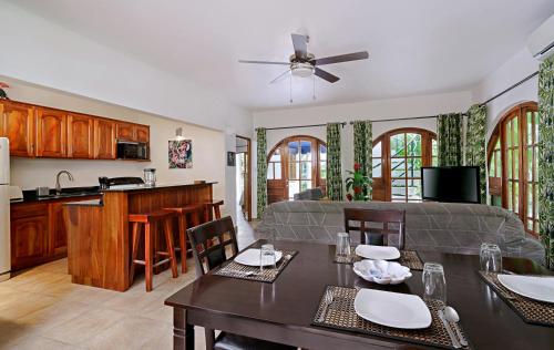 a kitchen and living room with a table and a couch at Beach House Condos, Negril in Negril