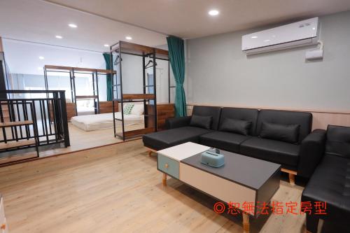 a living room with a black couch and a table at Chief Homestay輕旅套房附設電梯#本國旅客須先匯款 in Tainan