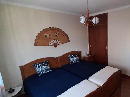 um quarto com uma cama azul e branca com 2 almofadas em Buarcos Beach House em Buarcos