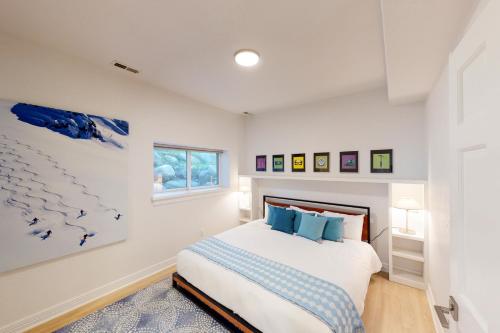a white bedroom with a bed with blue pillows at Springs of Arrowhead in Edwards