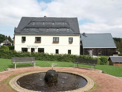 a building with a fountain in front of a building at Spacious holiday home in the Ore Mountains in Deutschneudorf