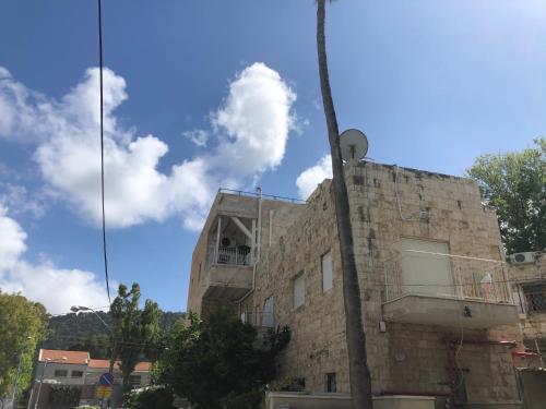 an old stone building with a blue sky and clouds at Bat Galim - by the sea in Haifa