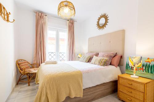 a bedroom with a large bed and a chair at Apartamento Vicky Victoria in Málaga