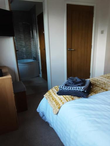 a bedroom with a bed and a bathroom with a tub at Snoozefrome in Frome