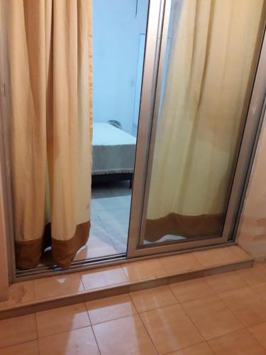 sypialnia ze szklanymi drzwiami i lustrem w obiekcie Departamento Anita centro w mieście Maipú