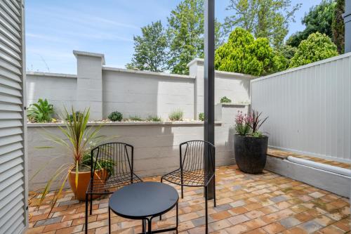 a patio with two chairs and a table at Wildes Hotel Kangaroo Valley in Kangaroo Valley