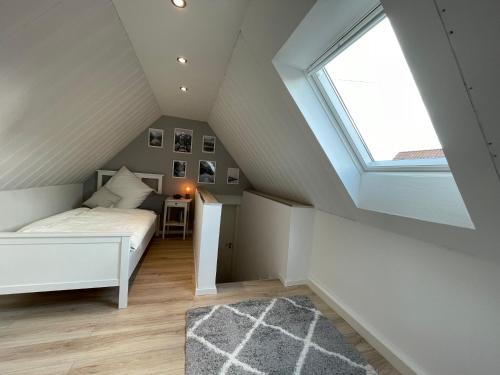 a attic bedroom with a bed and a window at AR Apartments II I 5 Pers I Prime I Küche I WLAN I am Thüringer Meer in Unterwellenborn