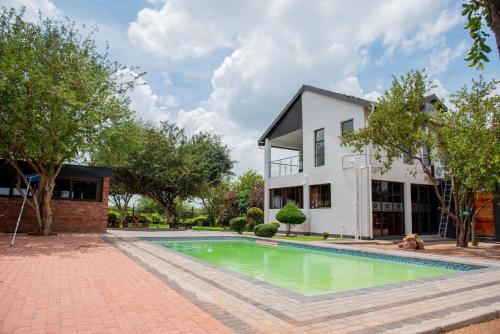 uma imagem de uma piscina em frente a uma casa em Boruundi Private Lodge & Campsite em Bokaa